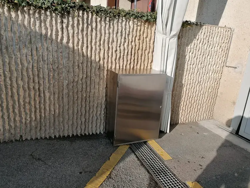 Caisson en inox au pied d'une façade